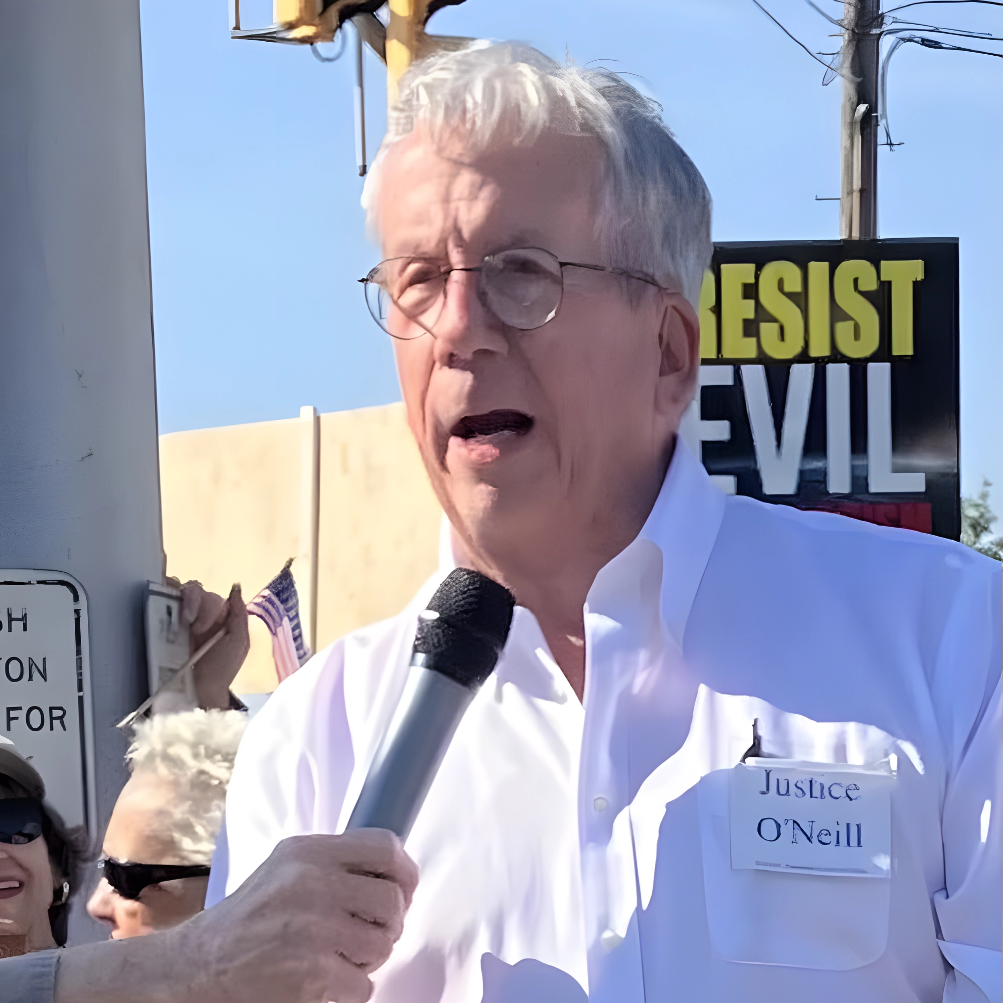 Bill O'Neill speaking to a microphone.